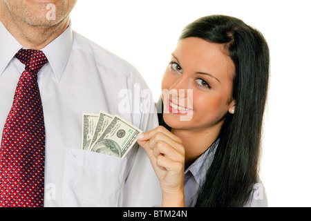 Eine junge Frau zieht das Geld aus der Tasche eines Mannes. Dollar Stockfoto