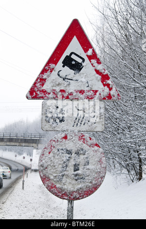 Eine verschneite Verkehrszeichen glatt oder vereisten Straßen im winter Stockfoto