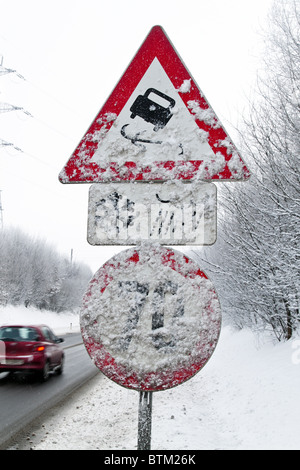 Eine verschneite Verkehrszeichen glatt oder vereisten Straßen im winter Stockfoto