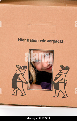 Kind im Karton. Liegt in der Box, beim bewegen. Stockfoto