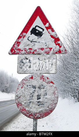 Eine verschneite Verkehrszeichen glatt oder vereisten Straßen im winter Stockfoto
