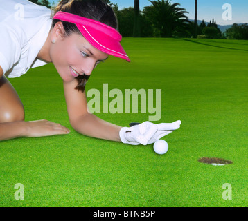 Grün Loch Kurs Frau Humor flicking hand eine Kugel im Inneren kurz Golf putt Stockfoto