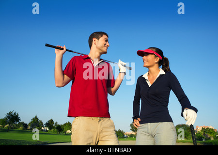 Golfplatz Nachwuchsspieler glücklich Paar posiert auf Bunker im Gespräch Stockfoto