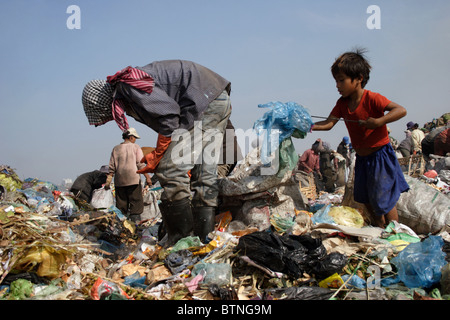 Ein Kind Arbeiter junge sammelt blauen Plastiktüten in einer verschmutzten Müllkippe in Kambodscha. Stockfoto