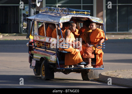 Eine Gruppe von jungen Mönchen fahren in einem Tuk-Tuk in Pakse, Laos. Stockfoto