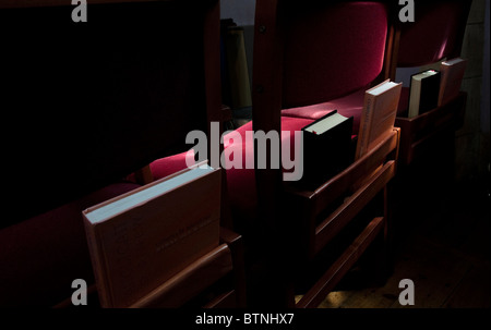 Rückseite einer Reihe von Stühlen mit Gebet und Hymne Bücher mit Stuhl Sitz durch Sonnenlicht hervorgehoben Stockfoto