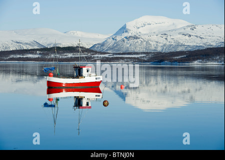 Kleine rote Smack, Fischerboot, auf ruhiger See. Der Berg Tromsdalstinden im Hintergrund. Tromsø, Nordnorwegen Stockfoto