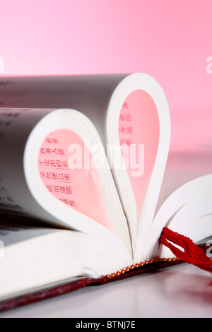Seiten eines Buches gebogen in Form eines Herzens. Stockfoto