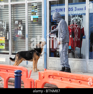 Ein Teenager Hoodie mit Wasser zu einem gefährlichen Hund in einer Straße U.K. Stockfoto