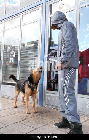 Ein Teenager Hoodie mit Wasser zu einem gefährlichen Hund in einer Straße U.K. Stockfoto