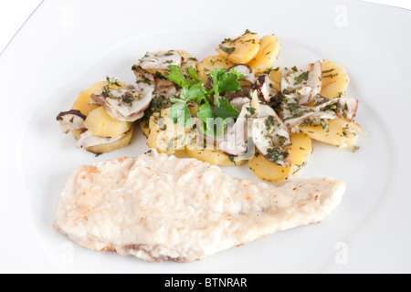 Hähnchen Schnitzel mit Bratkartoffeln und Pilze isoliert auf weiss mit Beschneidungspfad Stockfoto