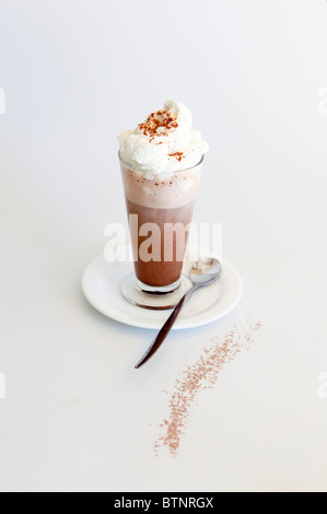 Heiße Schokolade Milch garniert mit Schlagsahne auf weißem Hintergrund Stockfoto