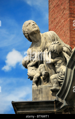 Skulpturen (Frau schützen Kinder vor dem Teufel) über dem Haupteingang an der St.-Michaelis-Kirche in Hamburg, Deutschland. Stockfoto