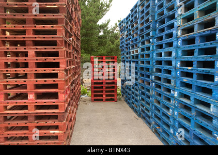 Stapel von rot und blau lackiert Holzpaletten, verwendet in der Transportbranche Stockfoto