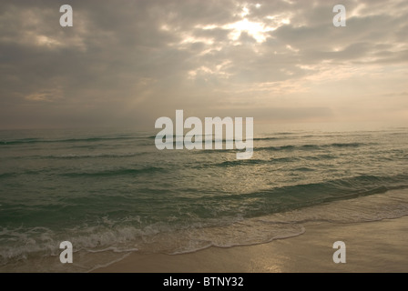 Das smaragdgrüne Wasser der Golfküste in Florida mit bewölkten Himmels bei Sonnenuntergang. Stockfoto