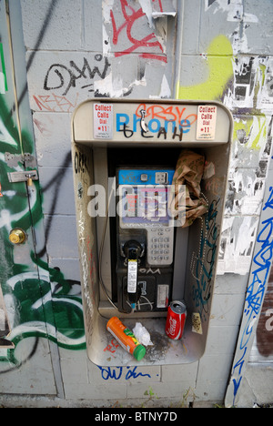 Eine vandalisierte und vernachlässigte öffentliche Telefonzelle, bedeckt mit Graffiti an einer Straßenecke im Kensington Market District von Toronto, Kanada Stockfoto