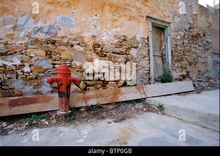 Hydranten gegen eine alte Wand altersschwache Stein in Ermoupolis, auf den griechischen Kykladen Insel Syros. Stockfoto