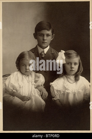 1908 Foto von drei Geschwistern. Ein Junge und zwei Mädchen. Stockfoto