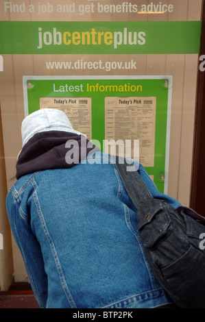 Frau auf der Suche nach Stellenangeboten im Fenster der Job Centre Plus, Cromer, Norfolk, England, UK Stockfoto