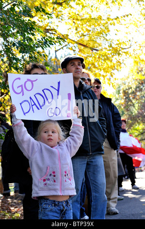 New York - 7. November 2011: Niedliche kleine Mädchen im Publikum hält Schild mit der Aufschrift Go Daddy beobachten die New York City Marathon 2010 Stockfoto