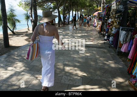 Eine junge Dame Spaziergänge entlang der schattigen Allee in der Nähe von Strand von Bol auf der Insel Brac, Kroatien Stockfoto