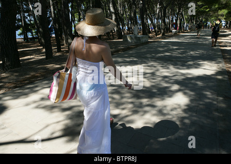 Eine junge Dame Spaziergänge entlang der schattigen Allee in der Nähe von Strand von Bol auf der Insel Brac, Kroatien Stockfoto