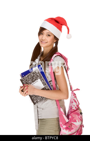 Asiatische Schulmädchen rote Weihnachtsmann Hut mit Rucksack hält Zusammensetzung Buch, Notebooks und Stift Stockfoto