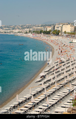 Frankreich, Nizza Promenade des Anglais, große Anzahl von Sonnenliegen und Menschen am Strand und Stadt im Hintergrund Stockfoto