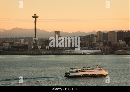 Ein wunderschönen Sonnenaufgang leuchtet der Space Needle und eine Fähre bringt Pendler in die Innenstadt von Seattle, Washington, USA. Stockfoto