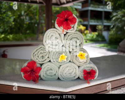 Handtücher, häuften sich in kunstvollen Dreieck mit den Blumen am Pool im Melia Bali Hotel Bali Nusa Dua-Indonesien Stockfoto