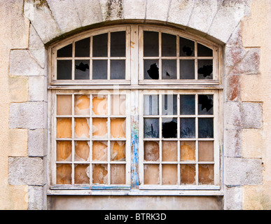 Gewölbte Fenster mit zersprungenen Fensterscheiben aus Glas Stockfoto