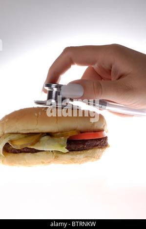 Stethoskop auf ein Fast-Food-Hamburger gelegt. Stockfoto