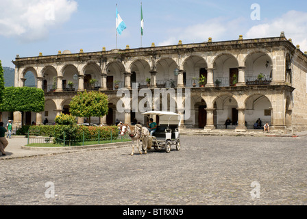 Pferd und Kutsche vor Palacio de Ayuntamiento oder Rathaus mit Blick auf den Parque Central, Antigua, Guatemala. Stockfoto