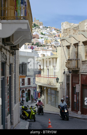 Menschen, die ihre Motorradfahren auf einer typischen schmalen Straße von Ermoupolis auf der griechischen Kykladen Insel Syros Stockfoto