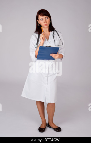 Junge Ärztin zuversichtlich in nachdenklicher Pose für ärztliche Untersuchung bereit. Stockfoto