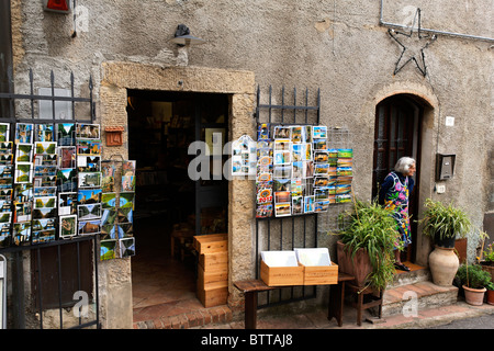 Bunte Postkarten vor einem Geschäft in Bolgheri und alte Lookimg aus ihrer Tür, Toskana, Italien Stockfoto