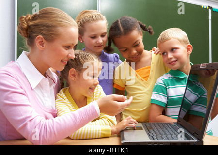 Porträt von Schülern Blick auf dem Laptop beim hören Lehrer etwas zu erklären Stockfoto