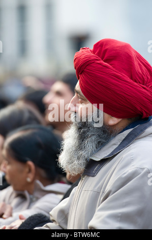Ein männlicher Sikh mit roten Turban, statt hört aufmerksam zu einer Rede an das Diwali-fest in Trafalgar Square in London. Stockfoto