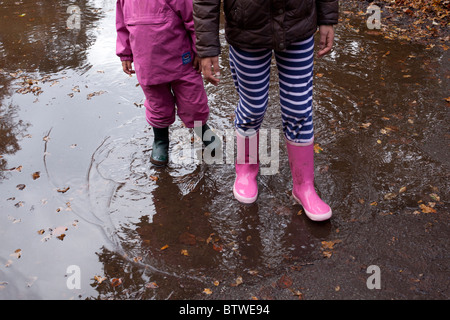 Kinder spielen in Pfütze Stockfoto