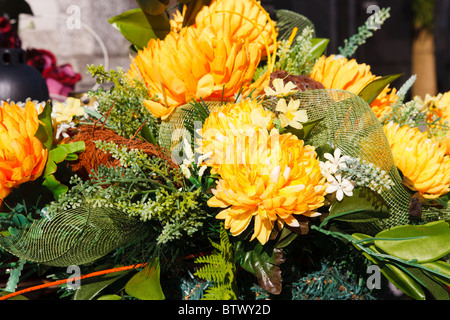 Rosenstrauss gelb künstliche Blumen liegen auf einem Grab Stockfoto