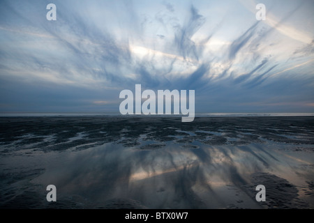 Dramatischer Himmel reflektiert in Wasser bei Sonnenuntergang am Strand von Le Touquet, Frankreich Stockfoto