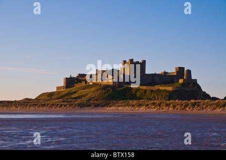 Frühen Morgenlicht über Bamburgh Castle und Strand in Northumberland, England. Stockfoto