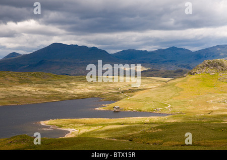 Licht über das Bootshaus am Devoke Wasser, einer abgelegenen Tarn in die westliche Seenplatte, Cumbria, England. Stockfoto