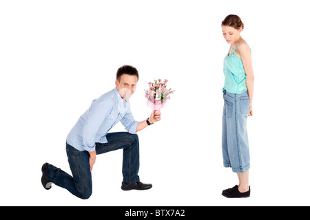 Glücklichen hübscher junger Mann Übergabe einer Blumen an einer schönen jungen Frau, die isoliert auf weiss Stockfoto