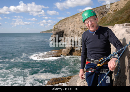 Ein 75 Jahre alter Mann lernen, Klettern an der Dancing Ledge Purbeck Dorset in England Stockfoto