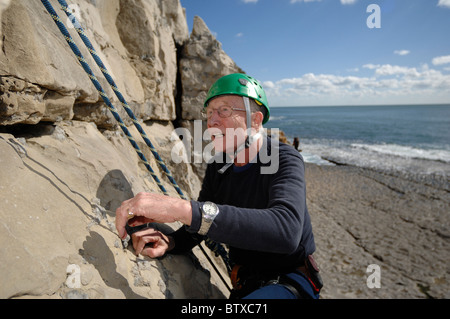 Ein 75 Jahre alter Mann lernen, Klettern an der Dancing Ledge Purbeck Dorset in England Stockfoto