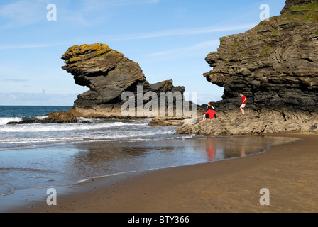 Jungs spielen auf den Felsen am Llangranog, Ceredigion, Westwales Stockfoto