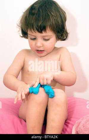 22 Monate Baby Junge saß auf seinem Bett mit blauen Play-Doh spielen Stockfoto