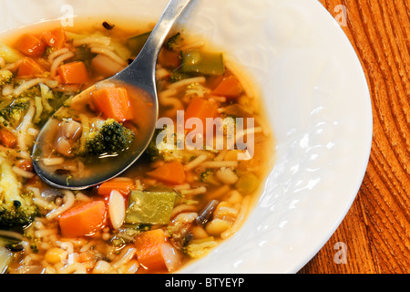 Weiße Schale mit herzhafte hausgemachte Gemüsesuppe auf Holz Küchentisch, gut für Ihre Gesundheit und ihr Bauch. Stockfoto