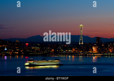 Ein wunderschönen Sonnenaufgang leuchtet der Space Needle und eine Fähre bringt Pendler in die Innenstadt von Seattle, Washington. Stockfoto